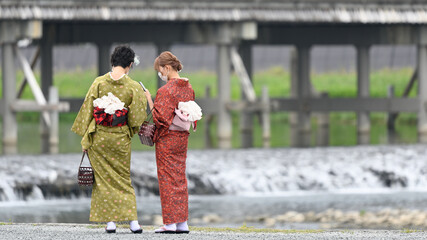 京都の嵐山を旅する着物の女性