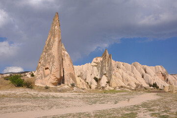 Fototapeta premium Scenic landscape view of a trail winding through the surreal landscape of Cappadocia, Turkey, on a cloudy day