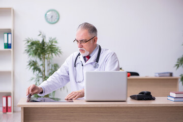 Old male doctor radiologist working in the clinic