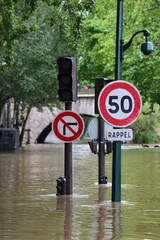 Traffic light and traffic signs standing in a flooded road , Paris France