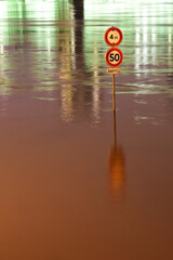 Traffic signs standing in a flooded road