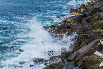 Olas de mar rompiendo contra las rocas en la playa