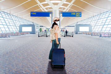 Young woman wearing face mask in airport terminal