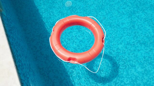 Safety equipment, Life buoy or rescue buoy floating on swimming pool to rescue people from drowning man, slow motion