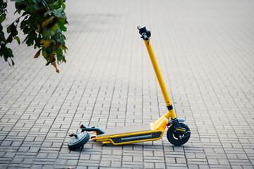 Torn off rear wheel on rent scooter. Mechanical damage of wheel on e-scooter, broken and abandoned motorized scooter. Defective scooter for rent in public park. Vandalism concept © Tricky Shark