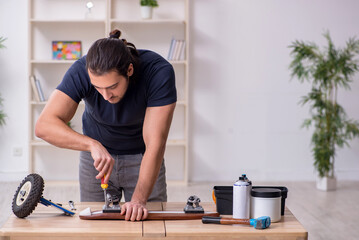 Young male repairman repairing skateboard