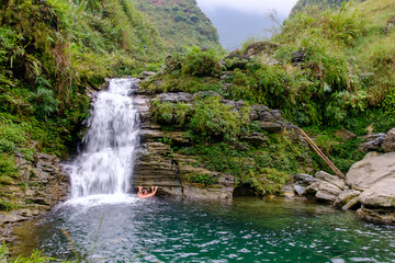 A couple holds each other while swimming under the Du Gia waterfall in Ha Giang in northern Vietnam