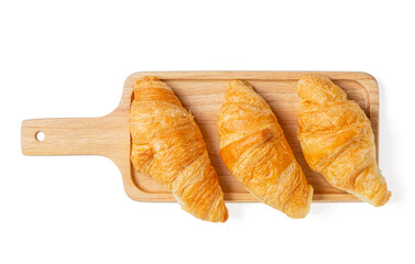 Croissants on wooden bread cutting board over white background with clipping path. Croissant french breakfast. Top view.