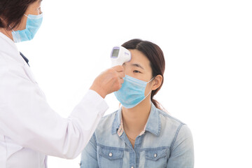 A doctor wearing a mask is taking the body temperature of a patient wearing a mask