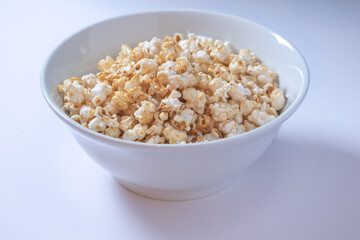 Fototapeta na wymiar White bowl with sweet popcorn on white background