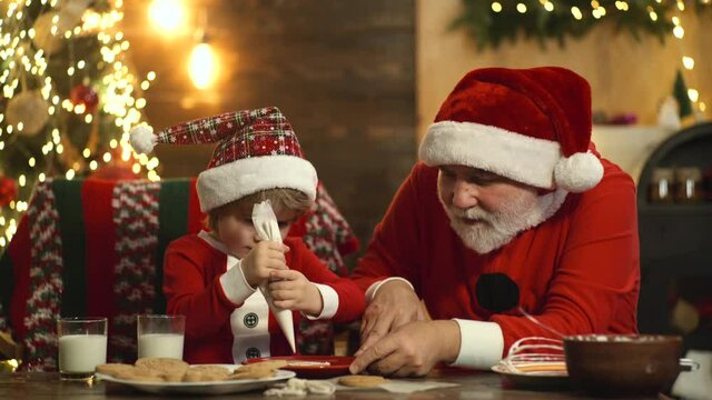 Santa and child make funny face and baking Christmas cookies in the vintage kitchen.