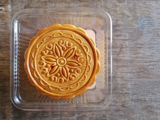Moon cake put in plastic box put Placed on a wooden floor.