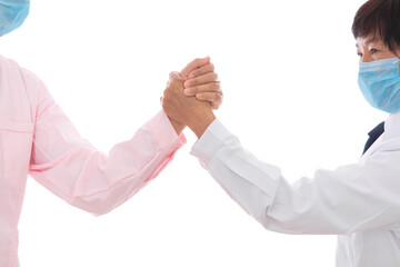 Hands of nurse and doctor clasped together in front of white background