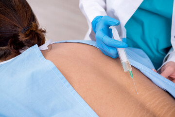 Young back injured man visiting female doctor chiropractor