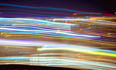 Abstract of multicolored Lights stripes moving fast in dark background. Orange violet and blue backdrop from fast city Light trails moving glow futuristic in black