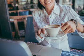 Smiling happy asian woman sitting When she drank coffee,