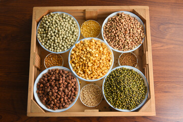 Various sources of vegetable protein beans, lentils, peas, chickpeas, mung bean in bowls. Indian Pulses uncooked , Lentils, Rice healthy balanced diet for vegans and vegetarians. Legumes assortment