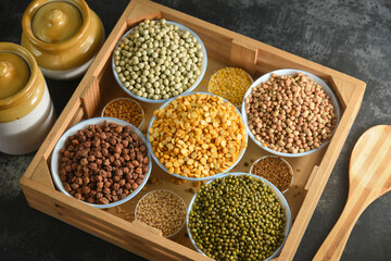 Various sources of vegetable protein beans, lentils, peas, chickpeas, mung bean in bowls. Indian Pulses uncooked , Lentils, Rice healthy balanced diet for vegans and vegetarians. Legumes assortment