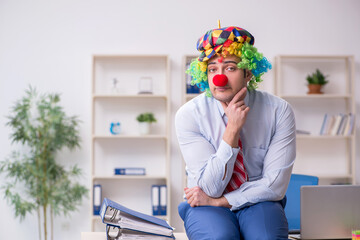 Funny employee clown working in the office