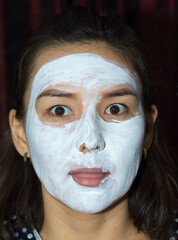 Fototapeta premium beautiful woman face white cream on black background