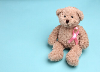 Teddy Bear pink ribbon on blue background.