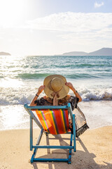 Woman sitting on a chair at the beach