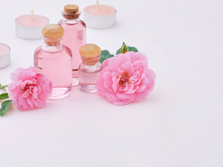 Fototapeta na wymiar Aromatherapy oil bottles and pink roses