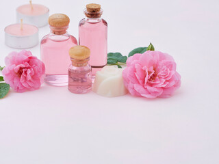 Obraz na płótnie Canvas Aromatherapy oil bottles and pink roses