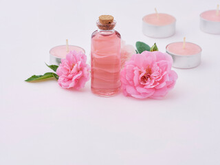 Obraz na płótnie Canvas Aromatherapy oil bottle and pink roses