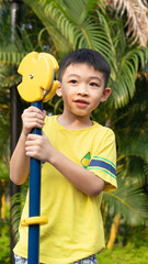 One boy is playing  in the park during Summer season.Child at the playground during the nice weather day.Outdoor activity after lock down at the public play area.