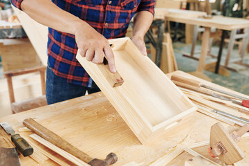 Cropped image of carpenter making wooden crate in his workshop