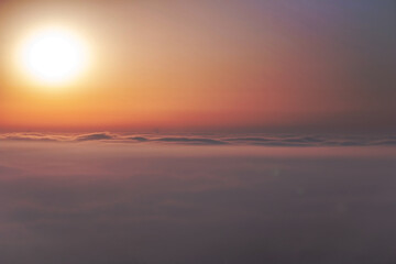 
Beautiful aerial view above clouds at sunrise. Fog above the city