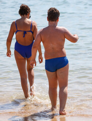 Boy and woman go swimming in the water