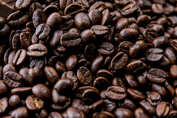 Brown roasted coffee beans, seed on dark background. Espresso dark, aroma, black caffeine drink. Closeup energy mocha, cappuccino ingredient.