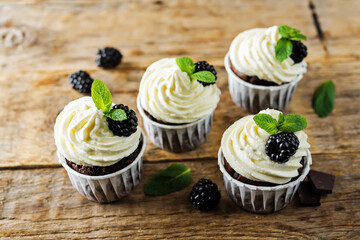 Chocolate banana cupcakes with cream cheese frosting and blackberries