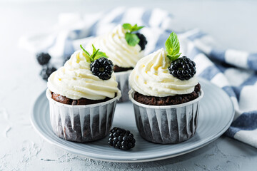 Chocolate banana cupcakes with cream cheese frosting and blackberries