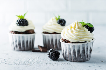 Chocolate banana cupcakes with cream cheese frosting and blackberries