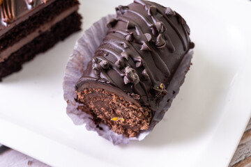 chocolate cakes pastries brownies on white ceramic plate with nuts topping  on a white wooden rustic desk table