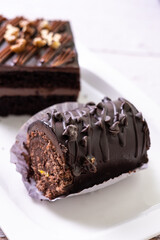 chocolate cakes pastries brownies on white ceramic plate with nuts topping  on a white wooden rustic desk table