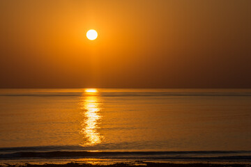 warm sunrise on the beach at the sea