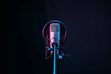 Poster Studio microphone and pop shield on mic in the empty recording studio with copy space. Performance and show in the music business equipment. © artitwpd