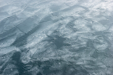 Fragile ice on a lake surface. Ice texture background.