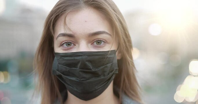 Cinema 4K 60 fps Young woman in black medical protective mask close-up. Covid concept health and safety, N1H1 coronavirus quarantine, second wave covid virus protection