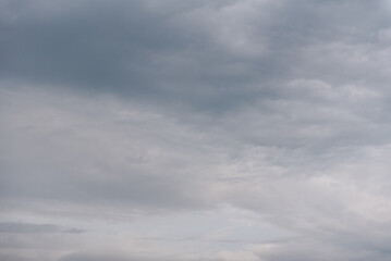 Grey sky. The sky is overhead. Clouds at sunset. The sky before the storm. Cumulus clouds. Gloomy sky