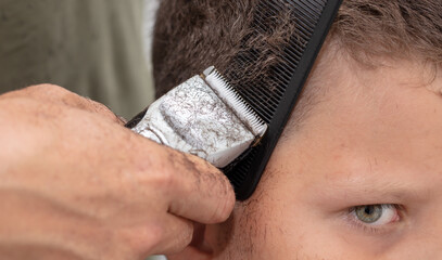 The boy is trimmed with a trimmer
