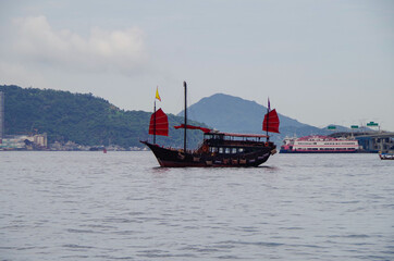 Traditonal Chinese junk with red sails in Victoria Harbor, Hong Kong in China