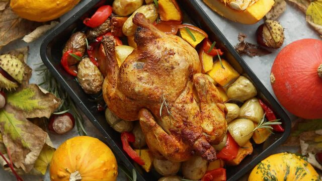 Roasted whole chicken or turkey with pumpkins, pepper and potatoes. With colorful mini pumpkins