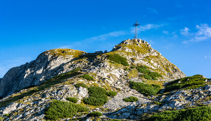 Fototapeta premium Cross at the top of Giewont. A popular tourist destination during the summer holidays. View on a beautiful sunny summer day.