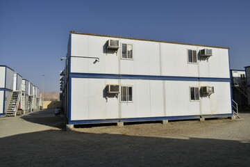 Naklejka na ściany i meble Portacabin, porta cabin, temporary labors camp , Mobile building in industrial site or office container Portable house and office cabins. Labor Camp. Porta cabin. small temporary houses