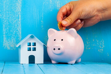 Female hand puts a coin into a piggy bank